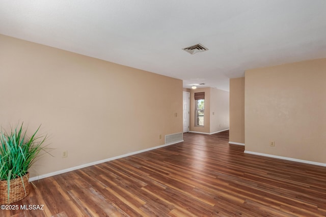 empty room featuring visible vents, baseboards, and wood finished floors