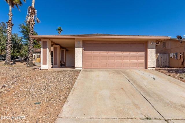 view of front of property featuring stucco siding, concrete driveway, and a garage