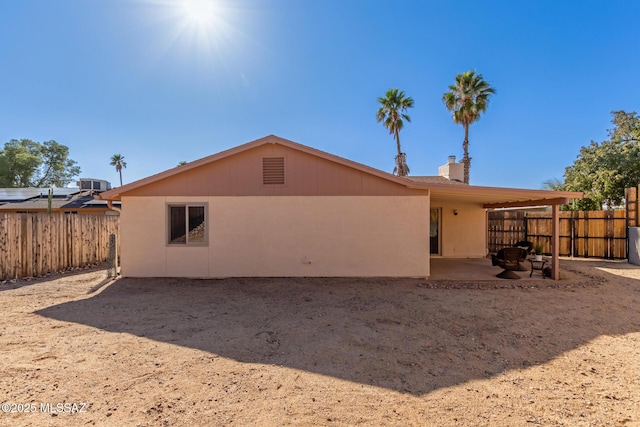 back of house with a patio area, cooling unit, a chimney, and a fenced backyard