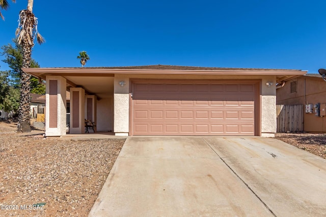 view of front facade featuring stucco siding, an attached garage, and concrete driveway