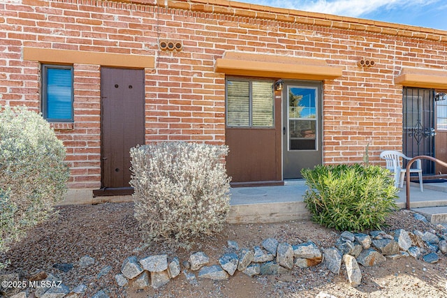 view of exterior entry featuring brick siding