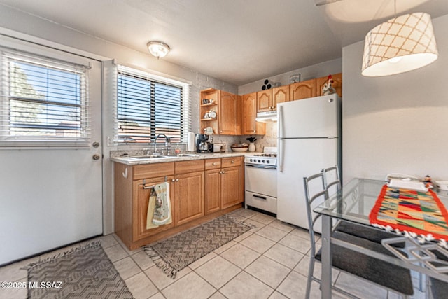 kitchen featuring under cabinet range hood, light countertops, light tile patterned flooring, white appliances, and a sink