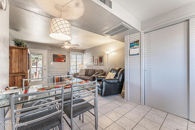 dining area with light tile patterned floors, visible vents, a textured ceiling, and ceiling fan