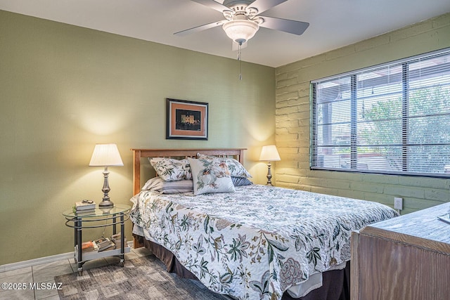 tiled bedroom with a ceiling fan and baseboards