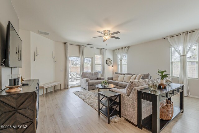 living area with visible vents, light wood-style flooring, and a ceiling fan
