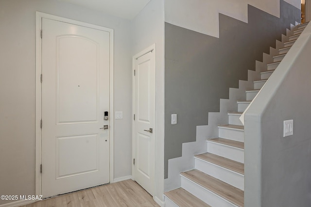 foyer featuring light wood-type flooring and stairway