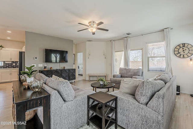 living area featuring a ceiling fan, recessed lighting, light wood-style floors, and visible vents
