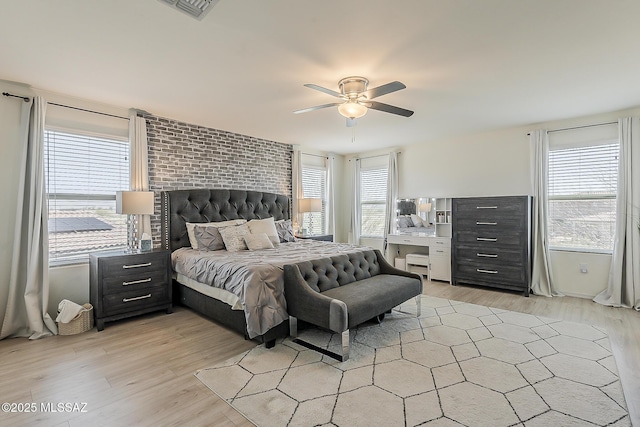 bedroom featuring multiple windows, light wood-type flooring, and ceiling fan