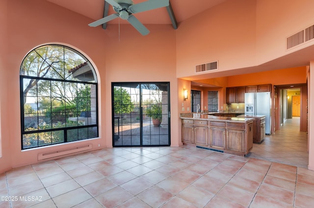 5460 N Paseo Pescado, Tucson, AZ 85718 - kitchen with stainless steel refrigerator with ice dispenser, visible vents, brown cabinets, and a baseboard radiator