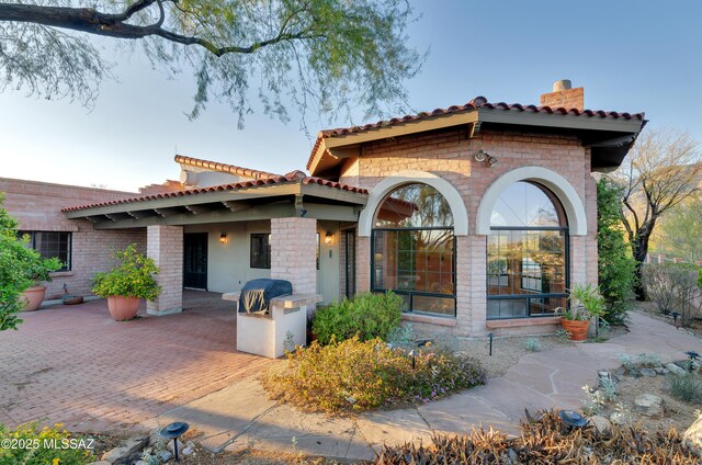 5460 N Paseo Pescado, Tucson, AZ 85718 - mediterranean / spanish-style house featuring a chimney, a tiled roof, and a patio