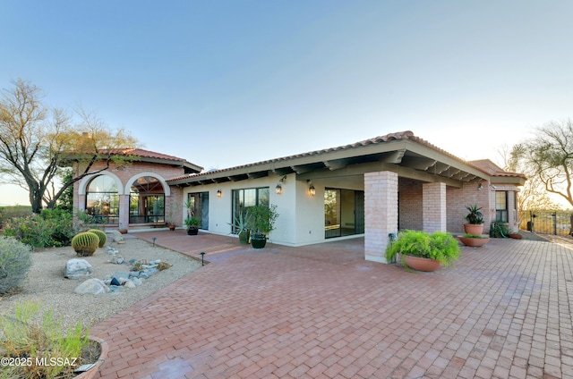 5460 N Paseo Pescado, Tucson, AZ 85718 - back of property featuring brick siding, a patio area, a tiled roof, and fence
