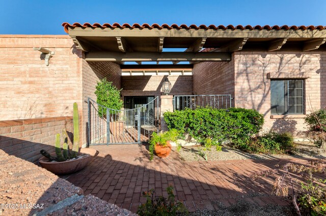 5460 N Paseo Pescado, Tucson, AZ 85718 - doorway to property featuring a gate and brick siding