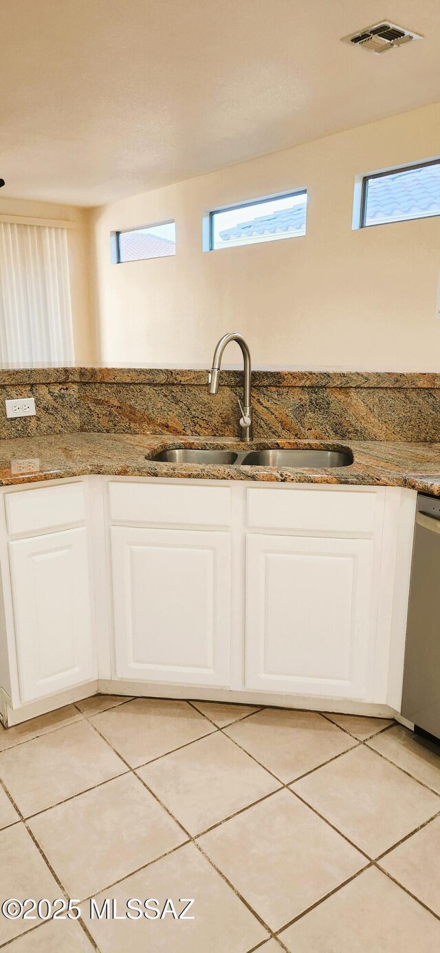 kitchen with a sink, dishwasher, a healthy amount of sunlight, white cabinets, and visible vents