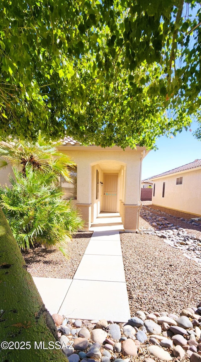 entrance to property featuring stucco siding
