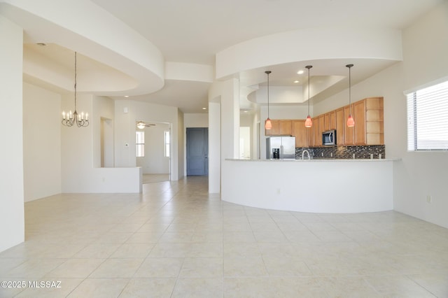11626 N Moon Ranch Pl, Marana, AZ 85658 - kitchen with decorative backsplash, a tray ceiling, appliances with stainless steel finishes, and pendant lighting