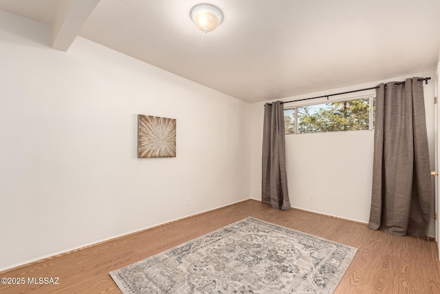 7267 E Eastview Dr, Tucson, AZ 85710 - spare room with light wood-style flooring and vaulted ceiling