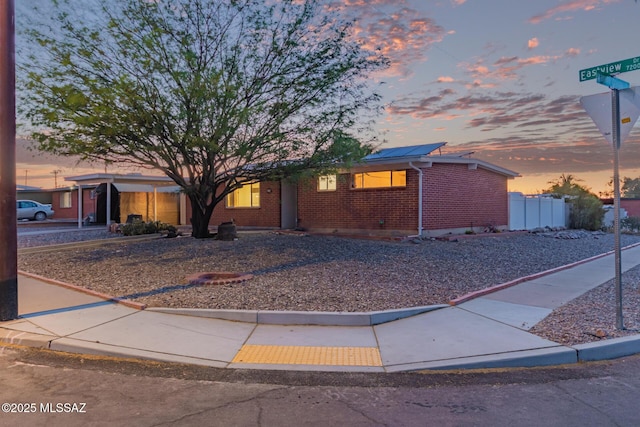 7267 E Eastview Dr, Tucson, AZ 85710 - single story home with brick siding and roof mounted solar panels
