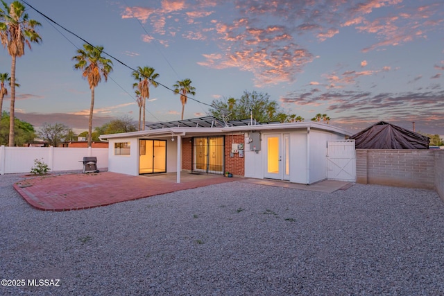 7267 E Eastview Dr, Tucson, AZ 85710 - rear view of house with a patio, a fenced backyard, a gate, and brick siding