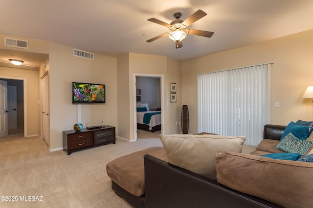 living room with light carpet, visible vents, baseboards, and a ceiling fan