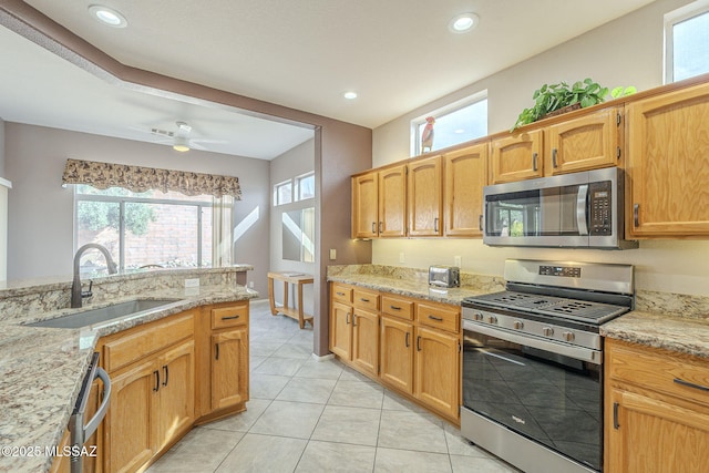 1117 E Regent Dr, Oro Valley, AZ 85755 - kitchen with light tile patterned floors, light stone countertops, appliances with stainless steel finishes, and a sink