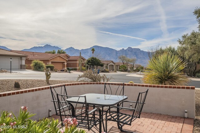 1117 E Regent Dr, Oro Valley, AZ 85755 - view of patio / terrace with a mountain view, outdoor dining area, an attached garage, and driveway