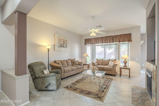 1117 E Regent Dr, Oro Valley, AZ 85755 - living area with visible vents, baseboards, a fireplace, light tile patterned flooring, and a ceiling fan