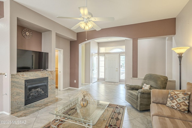 1117 E Regent Dr, Oro Valley, AZ 85755 - living area with a ceiling fan, a high end fireplace, arched walkways, light tile patterned flooring, and baseboards