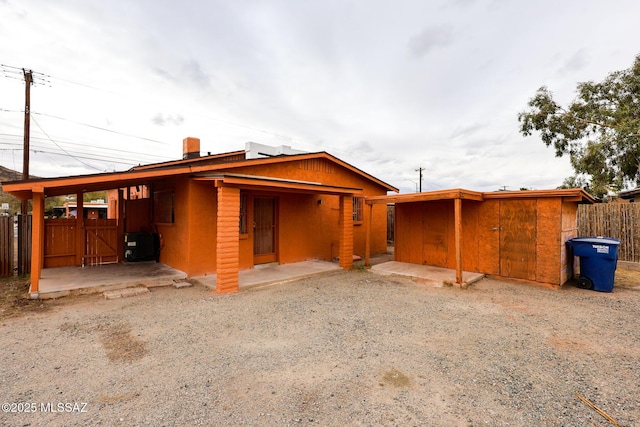exterior space with a patio area, an outdoor structure, and fence