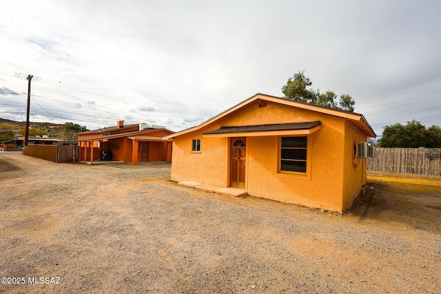 view of front of house featuring stucco siding and fence