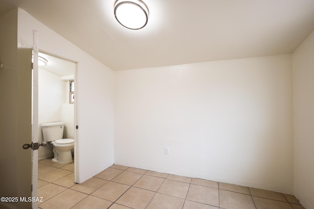 interior space with tile patterned floors and toilet
