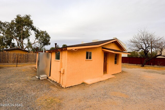 view of outbuilding featuring fence