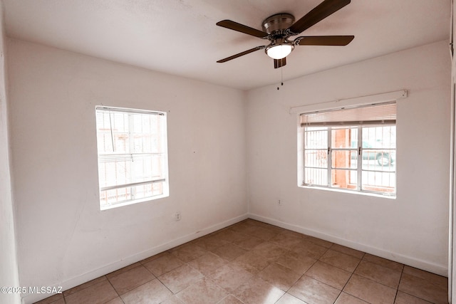 spare room with baseboards and ceiling fan