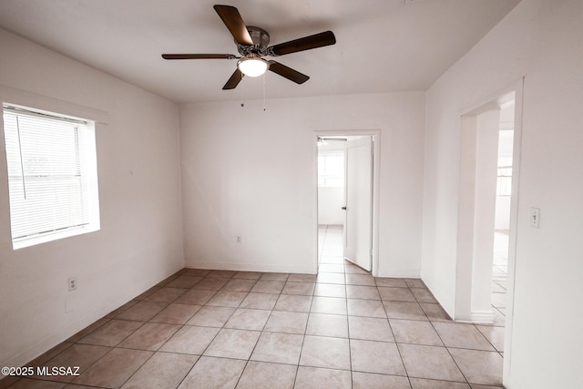 empty room with ceiling fan and light tile patterned flooring