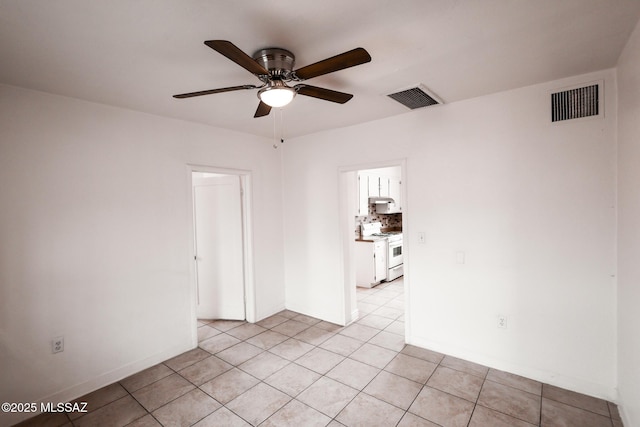 empty room with light tile patterned floors, visible vents, baseboards, and ceiling fan