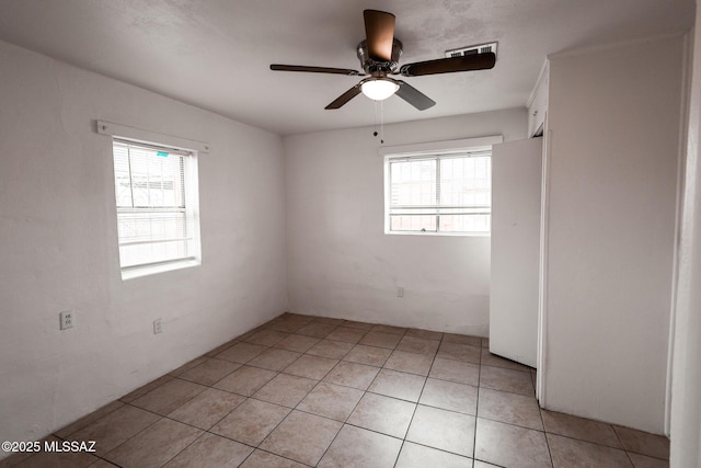 spare room with light tile patterned flooring and a ceiling fan