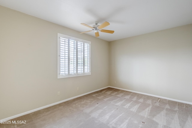 empty room featuring light carpet, baseboards, and ceiling fan