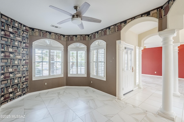 spare room with plenty of natural light, a ceiling fan, visible vents, and baseboards
