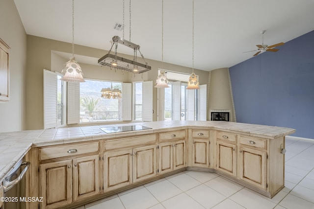 kitchen with light brown cabinetry, visible vents, a large fireplace, ceiling fan, and black electric stovetop