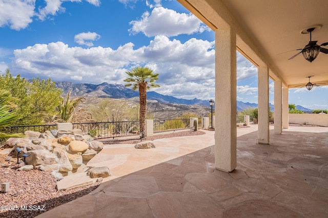 view of patio / terrace with a fenced backyard, a mountain view, and a ceiling fan