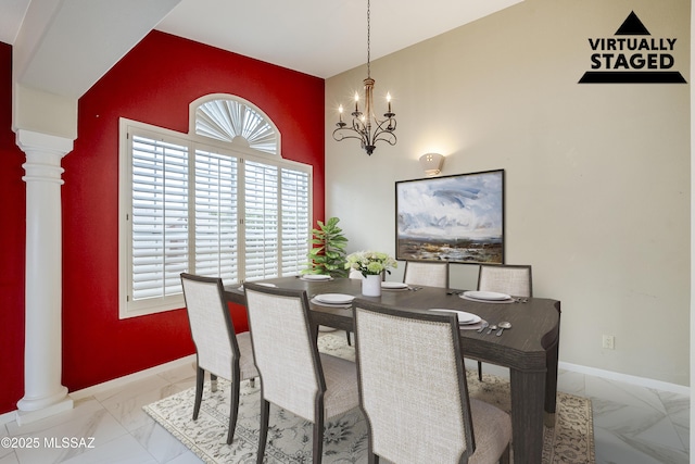 dining room featuring marble finish floor, baseboards, a towering ceiling, and decorative columns
