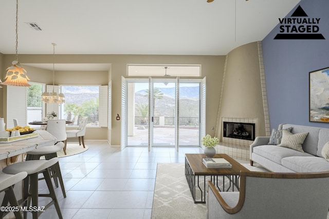 living area with baseboards, light tile patterned flooring, visible vents, and plenty of natural light