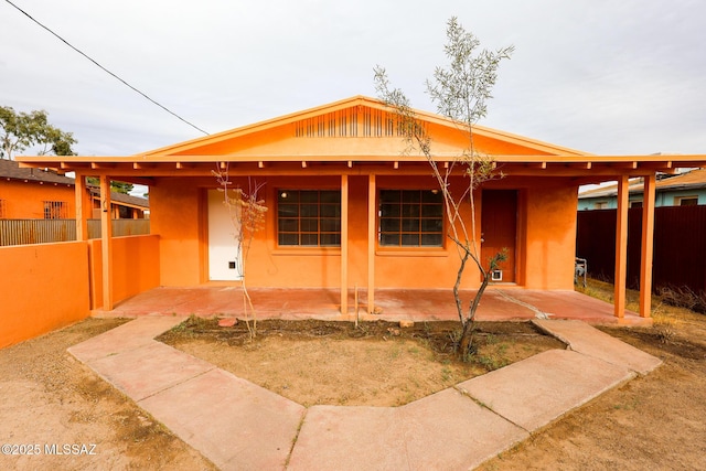 view of front of home featuring a patio and fence