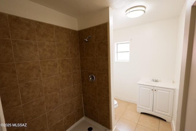full bath featuring vanity, toilet, tile patterned flooring, and a tile shower