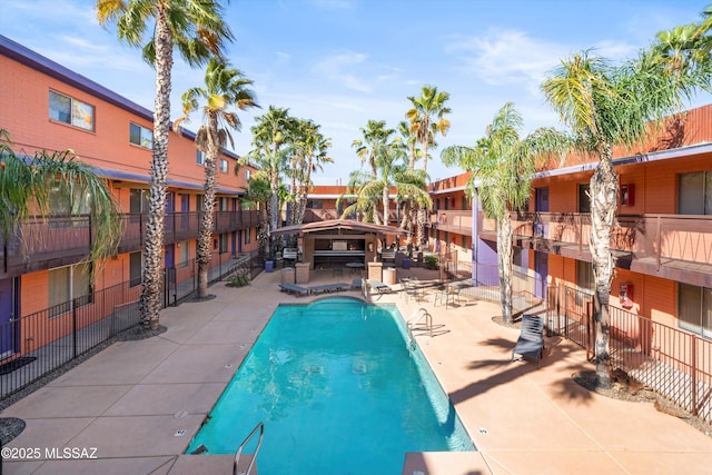 pool featuring fence and a patio area