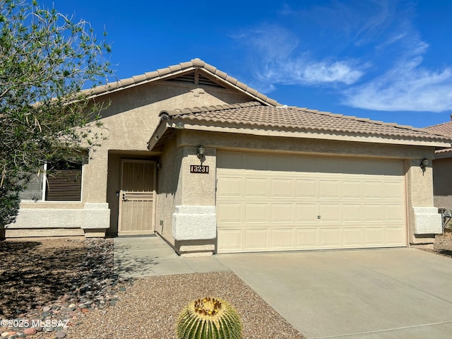 view of front facade featuring driveway, stucco siding, a tile roof, and a garage