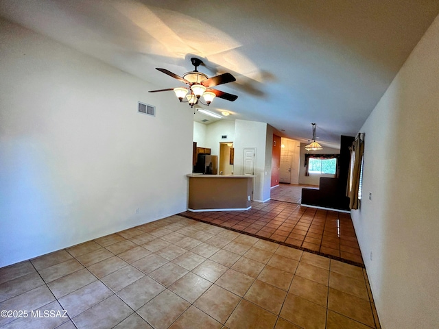 unfurnished living room with tile patterned floors, visible vents, vaulted ceiling, and ceiling fan