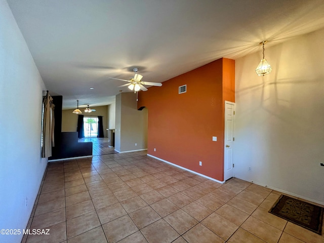 spare room with visible vents, baseboards, ceiling fan, light tile patterned flooring, and lofted ceiling