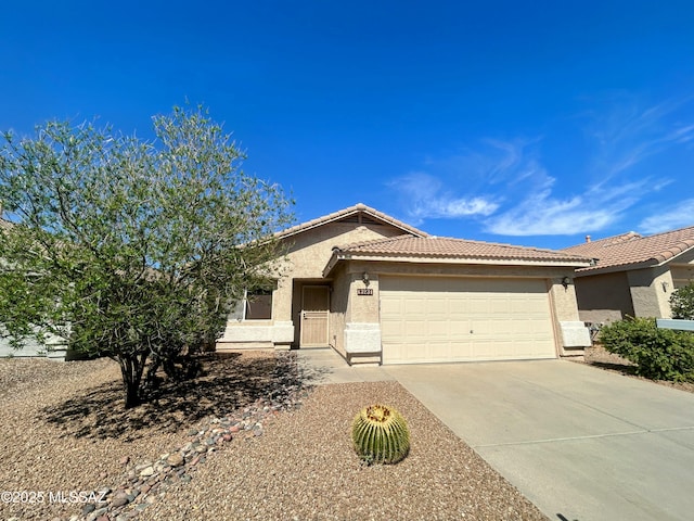 single story home featuring a garage, driveway, stucco siding, and a tile roof