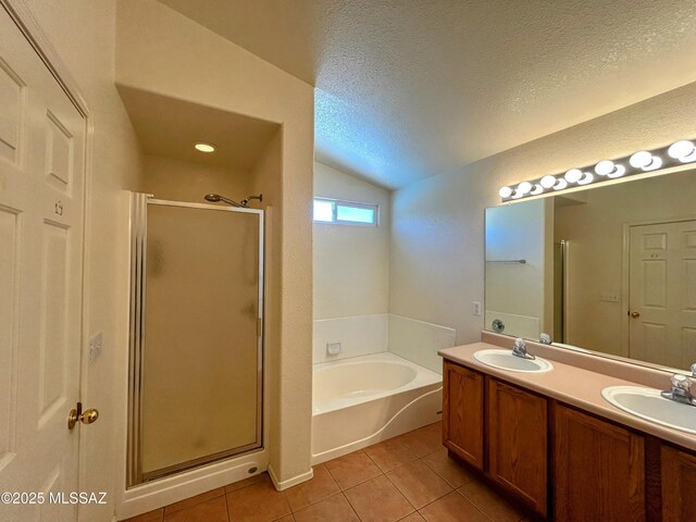 full bath featuring a stall shower, tile patterned floors, a bath, lofted ceiling, and a sink
