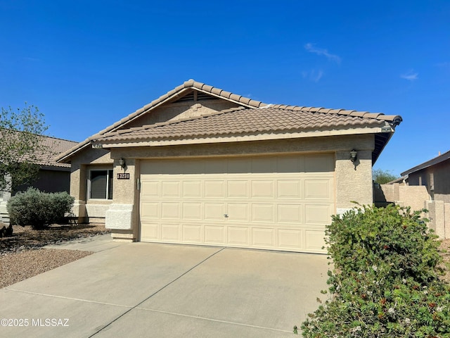ranch-style house with a tile roof, an attached garage, driveway, and stucco siding